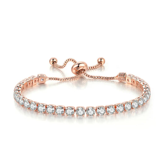 Plusieurs bracelets de couleur dorée portés au poignet, avec maillons, pierres décoratives et pendentif