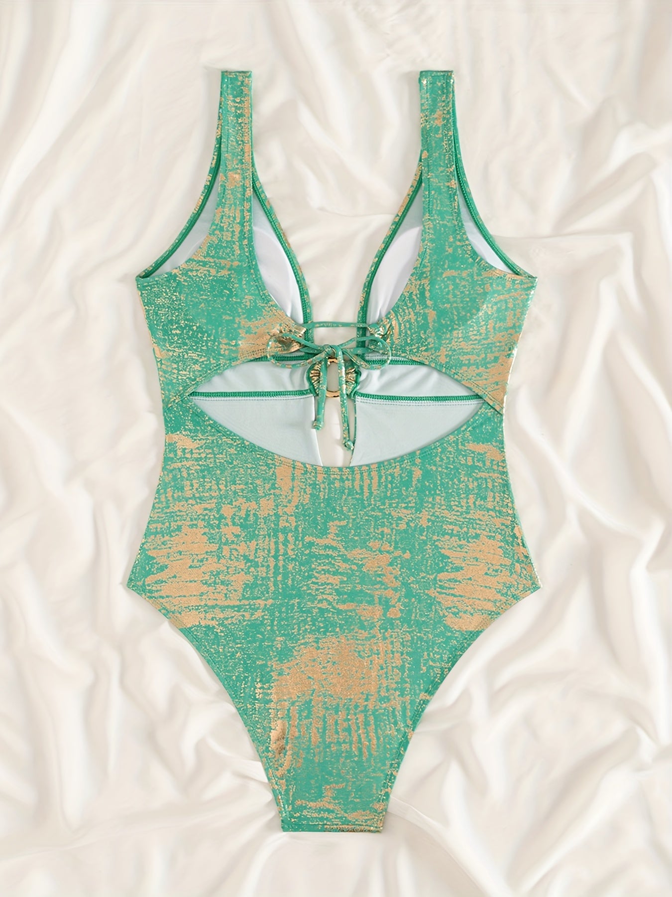 Trendy swimsuit in shiny fabric with a sexy deep V-neck and a bare back with a bow.